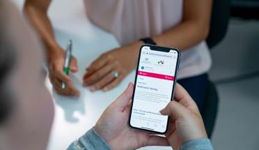 Photo: patient looking at notification settings on her phone