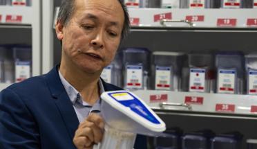 Man wearing a suit jacket looking at a device