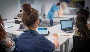 Group of healthcare workers in a training workshop with laptops on their desks