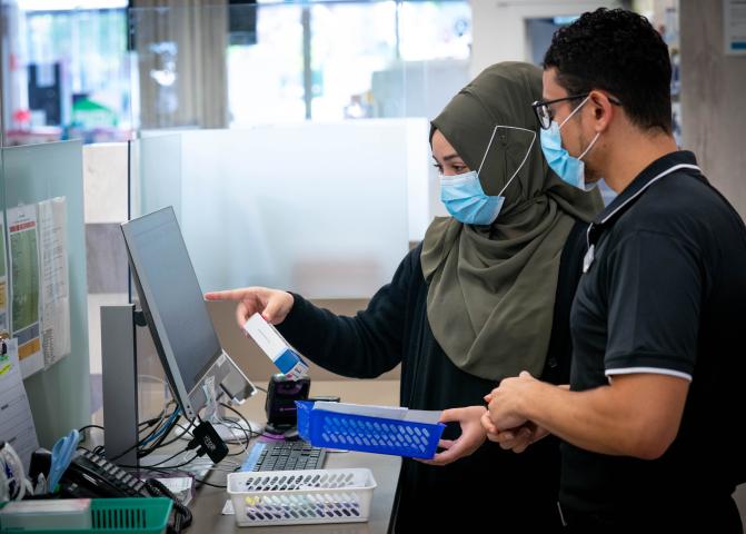 Man and woman dispensing medicine