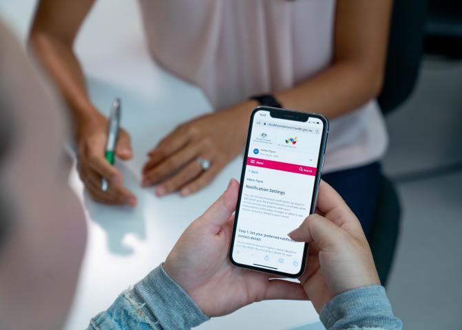 Photo: patient looking at notification settings on her phone