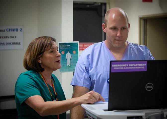 Two hospital staff looking at a monitor