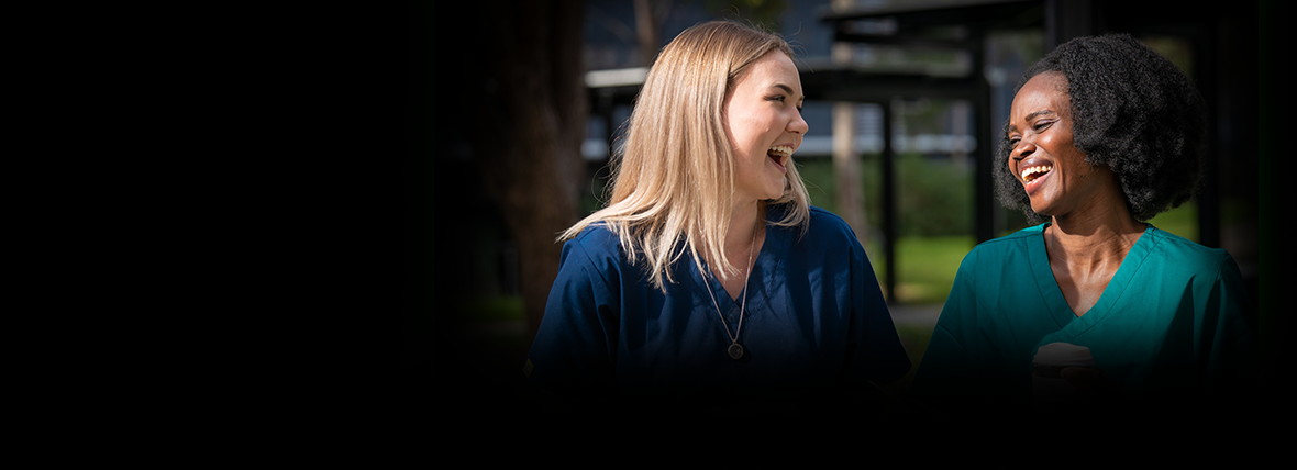 The Roadmap in Action is a curated collection of case studies which highlight the progress being made to advance digital health in Australia. Image contains two women laughing together, in green hospital uniforms, infront of a hospital.