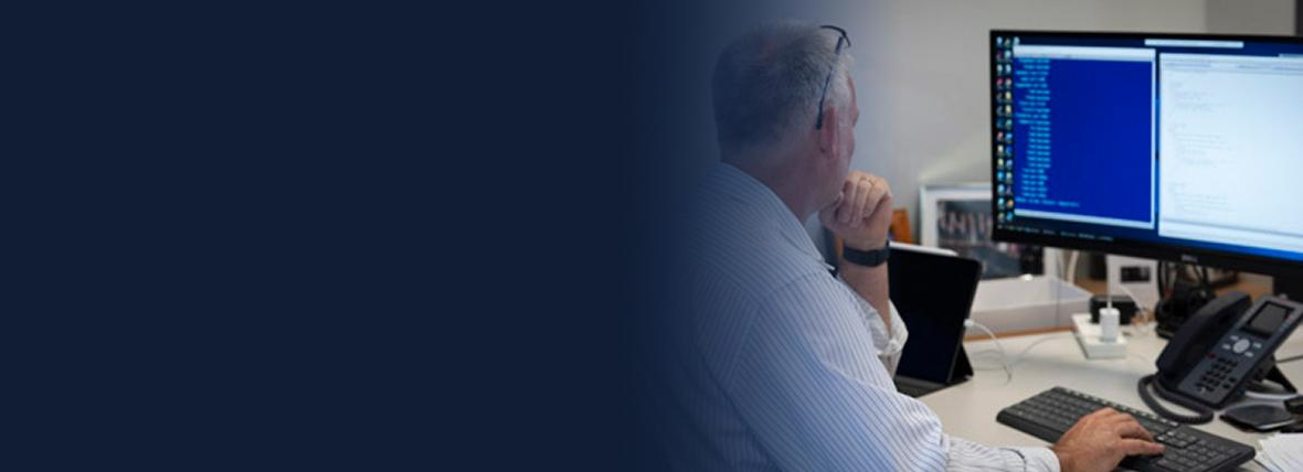 A pathologist reads data from a computer screen.