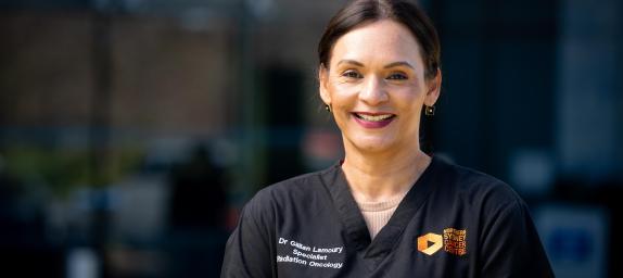 Digitally enabled outcome - Ensuring that health and wellbeing services are connected, safe, secure and sustainable. Smiling female hospital staff member in dark blue uniform