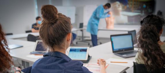 Group of healthcare workers in a training workshop with laptops on their desks