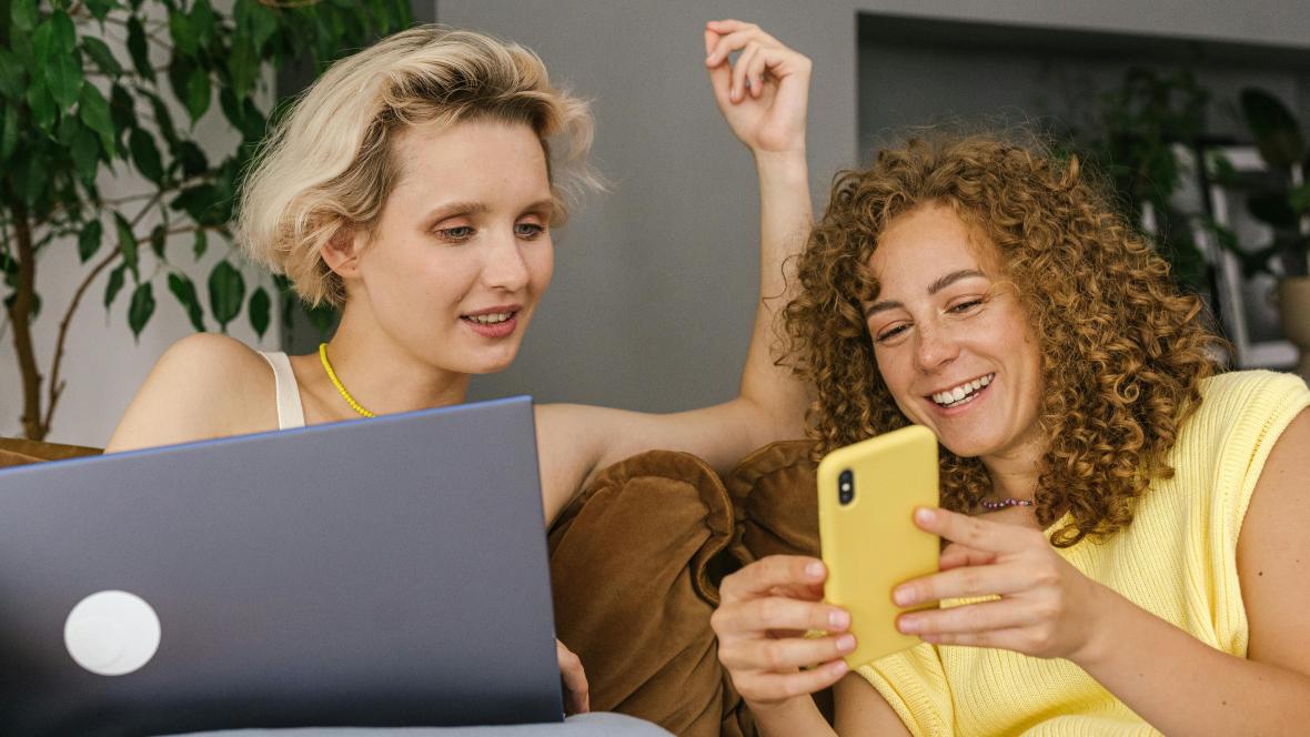 Two people looking at a phone device.
